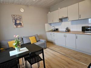 eine Küche und ein Wohnzimmer mit einem Tisch und einem Sofa in der Unterkunft Bingo in Powidz