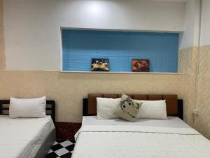 two beds sitting next to each other in a room at Vientiane Star Hotel B in Vientiane