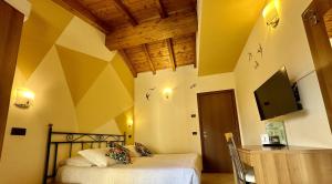 a bedroom with a bed and a flat screen tv at Dependance Pesce d'Oro in Verbania