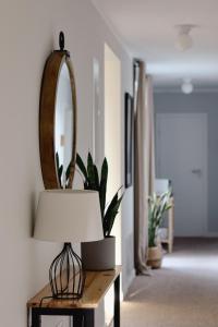 a lamp sitting on a table with a mirror at Busola House in Stegna