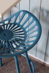 a blue chair sitting in front of a table at Busola House in Stegna