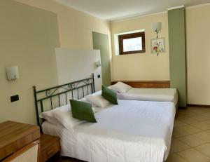 a hotel room with two beds with green accents at Dependance Pesce d'Oro in Verbania