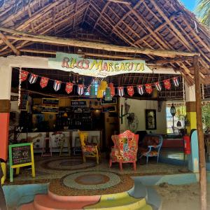 a shop with awning with chairs and a table at Fontaine Garden Village in Bwejuu