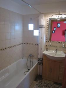 a bathroom with a bath tub and a sink at Casa No Chupal in São Brás de Alportel