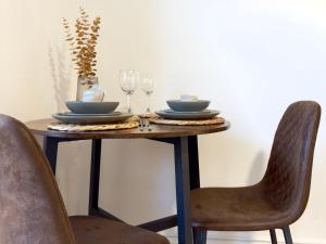 een tafel met twee stoelen en een tafel met glazen bij City Centre Apartment Near the University and Bodleian Library in Oxford