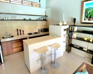 a kitchen with a counter and two stools in it at Villa Taman Rahasia in Seminyak