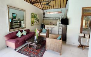 a living room with a red couch and a table at Villa Taman Rahasia in Seminyak