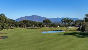 Blick auf einen Golfplatz mit Bergen im Hintergrund in der Unterkunft Sotogrande San Roque Cádiz in San Roque