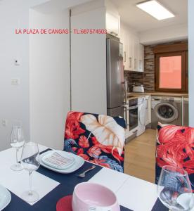 a kitchen with a table and chairs with wine glasses at La Plaza de Cangas Apartamento Turistico in Cangas de Onís