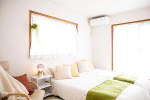 桑名市Nagashima Riverside House 4的有两张床和一扇窗户的卧室 更多33张照片