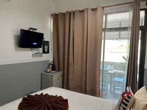 Habitación con cama, TV y ventana. en Labella samet guesthouse, en Ko Samed