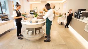 a group of people standing in a kitchen preparing food at Dependance Pesce d'Oro in Verbania