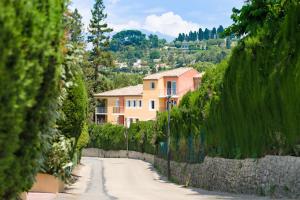 une maison sur une colline à côté d'un mur de pierre dans l'établissement Privilège Appart-Hôtel Domaine De Mai - parking gratuit, à Mougins