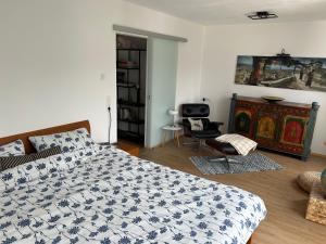 a bedroom with a bed and a chair in it at Cube - Ferienhaus mit Garten und Terrasse in Eberbach in Eberbach +7 photos