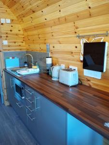 a kitchen with a counter with a television and a counter top at Aurora Skye in Breakish