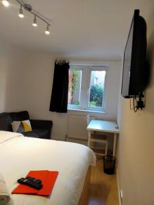 Dormitorio con cama, escritorio y TV en COBBOLD COURT share flat en Londres