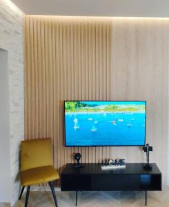 een woonkamer met een flatscreen-tv aan de muur bij Volos Guesthouse Konstantina in Volos