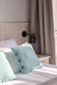 Una cama con una almohada azul encima. en Busola House, en Stegna