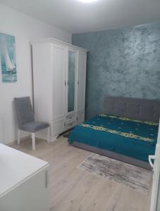 a bedroom with a bed and a chair in it at Mira Apart Hotel - Onesti in Onești