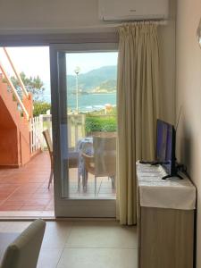 a room with a sliding glass door with a view of the ocean at Villetta a Schiera - Bosa Marina in Magomadas