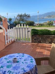 un patio con mesa, sillas y una valla en Villetta a Schiera - Bosa Marina, en Magomadas