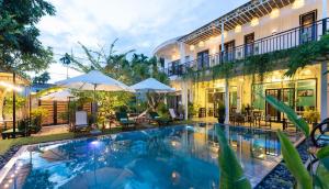uma imagem de uma piscina em frente a um edifício em Luna Verde Hotel Hoi An em Hoi An