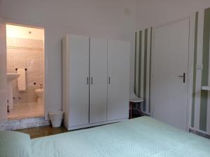 ジュルディニャーノにあるGli Archi Country Homeの白いキャビネット付きのベッドルーム、バスルーム