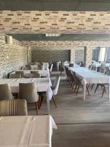 jadalnia ze stołami i krzesłami oraz ceglaną ścianą w obiekcie Werrapark Aktiv Hotel Am Sommerberg w mieście Masserberg