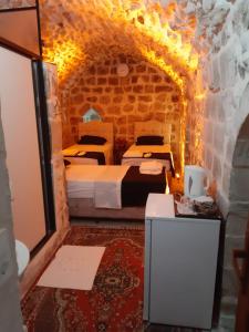 馬爾丁的住宿－Aydınbey konagı，石墙客房内的2张床