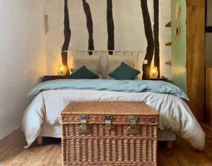 a bedroom with a large bed with a wicker trunkitures at Maison médiévale climatisée avec jardin in Monpazier