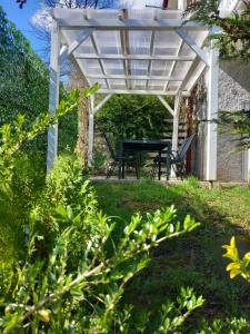 a white pergola with a table and chairs in a yard at Apartman Mr Guest Krapina in Krapina
