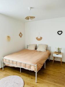 um quarto com uma cama num quarto branco em La Pomme de Pin em Scionzier