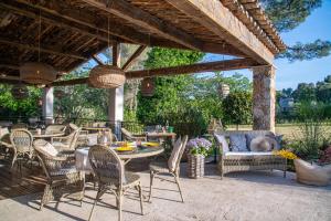 a patio with a table and chairs under a pavilion at Hotel Les Messugues in Saint Paul de Vence