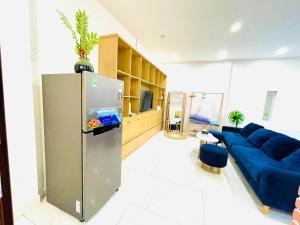 a living room with a blue couch and a refrigerator at TINA HOUSE Apartment in Da Nang