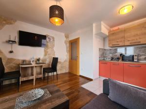 a kitchen and a living room with a table at Downtown Apartment Bepi in Opatija