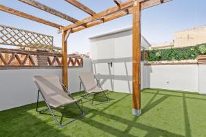 a patio with two chairs on the grass at Luxer Holidays in Málaga
