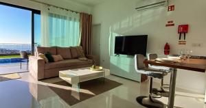 ein Wohnzimmer mit einem Sofa und einem TV in der Unterkunft The Tree of Life House in Ponta do Sol