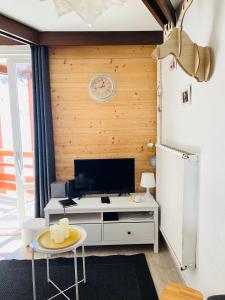 a living room with a tv and a table at Résidence Bero Bisto in La Mongie