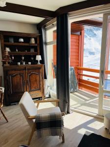 a living room with a chair and a sliding glass door at Résidence Bero Bisto in La Mongie