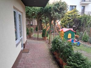 ein Gehweg führt zu einem Hof mit Spielhaus in der Unterkunft noclegi Julia in Kielce