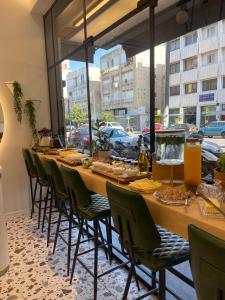 een lange tafel met stoelen en eten erop bij Levinski Market Hotel in Tel Aviv