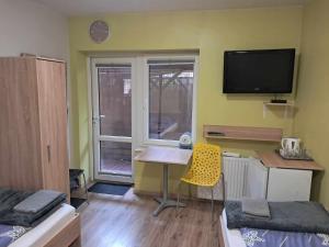 Habitación pequeña con escritorio y TV en la pared. en noclegi Julia en Kielce