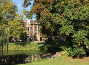 a large house with a pond in front of it at Hemels logeren LUXURY LOFT Zutphen in Zutphen