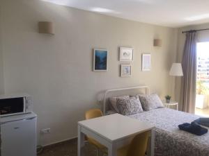 een kleine slaapkamer met een bed en een tafel bij Apartamento en el centro de Torremolinos in Torremolinos