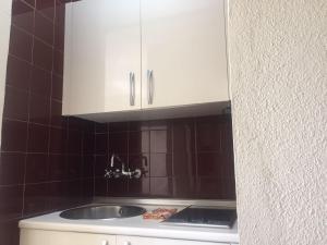 een keuken met een wastafel en witte kasten bij Apartamento en el centro de Torremolinos in Torremolinos