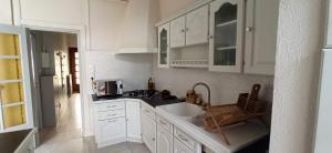 a white kitchen with a sink and a microwave at Le paradis face au marché in La Rochelle