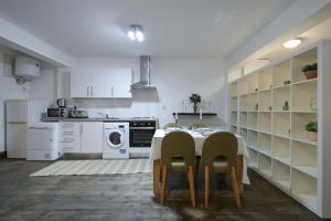 a white kitchen with a table and chairs in it at Stoke Newington Studio by DC London Rooms in London