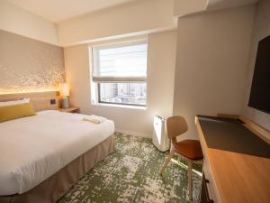 a hotel room with a bed and a desk and a window at Hotel Terrace the Garden Mito in Mito +37 photos