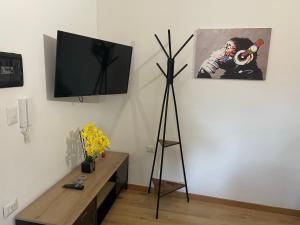 una habitación con TV en un trípode junto a una pared en Civico19, en Sassari