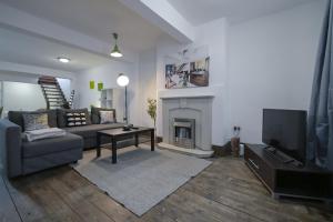 un soggiorno con divano e camino di Stoke Newington Studio by DC London Rooms a Londra